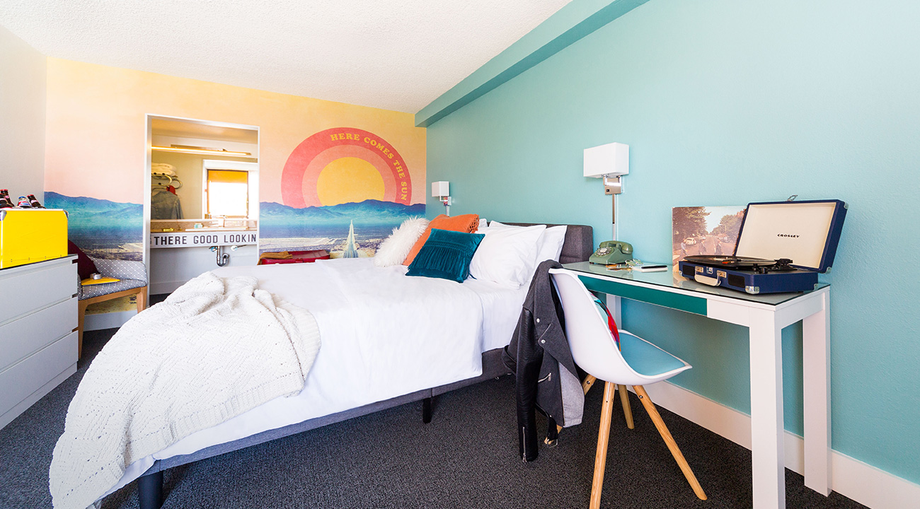 Interior of Rambler Motel guest room with Here Comes the Sun wall graphic